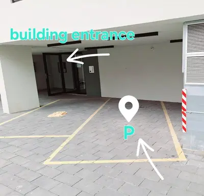 a building entrance with a parking lot with a building entrance at Brooklyn88 Apartment in Niš