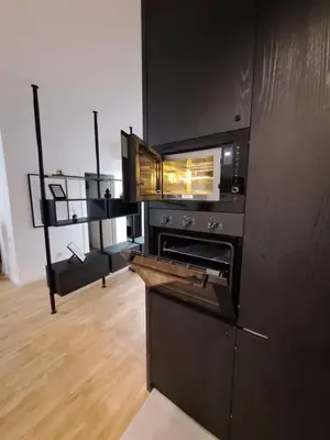 a kitchen with a black stove top oven in a room at Brooklyn88 Apartment in Niš
