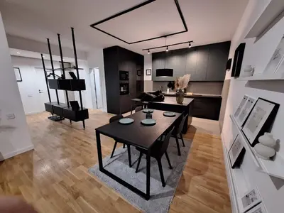 a living room with a dining table and a kitchen at Brooklyn88 Apartment in Niš