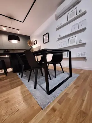 a dining room with a black table and chairs at Brooklyn88 Apartment in Niš