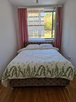 a bed in a bedroom with a window at Apartman AQUARELLE sa bazenom, Delux apartman sa bazenom in Vrnjačka Banja