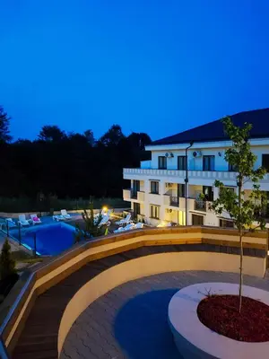 a bridge over a swimming pool in front of a building at Apartman AQUARELLE sa bazenom, Delux apartman sa bazenom in Vrnjačka Banja