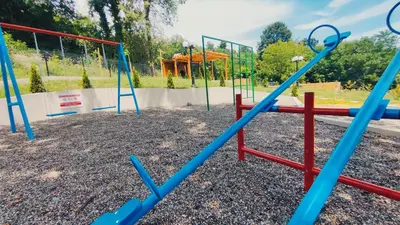 a playground with blue and red swings at Apartman AQUARELLE sa bazenom, Delux apartman sa bazenom in Vrnjačka Banja
