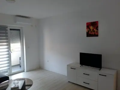 a living room with a tv on a dresser at Apartman Petrovic 3 in Soko Banja