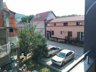 two cars parked in a parking lot next to buildings at Apartman Petrovic 3 in Soko Banja