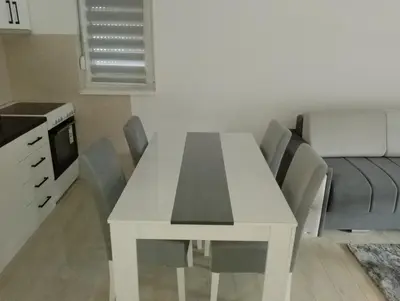 a white dining room table with chairs in a kitchen at Apartman Petrovic 3 in Soko Banja