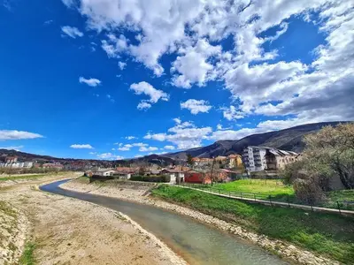 a winding river with houses and mountains in the background at Apartman Petrovic 3 in Soko Banja