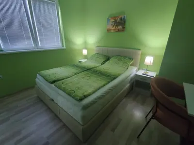 a bedroom with a bed with a green comforter at Apartman Kaoma in Soko Banja