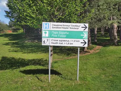a sign in the grass with arrows on it at Apartman Kaoma in Soko Banja