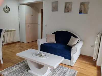 a living room with a blue couch and a table at Apartmani Lucky Place in Vrnjačka Banja