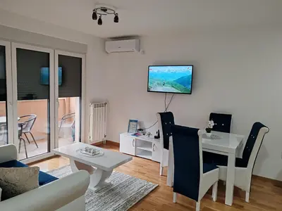 a living room with a table and a dining room at Apartmani Lucky Place in Vrnjačka Banja