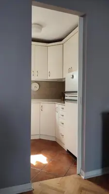 an empty kitchen with white cabinets and a refrigerator at Mila LOFT city center-free parking in Vranje