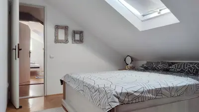 a bedroom with a bed and a skylight at Mila LOFT city center-free parking in Vranje
