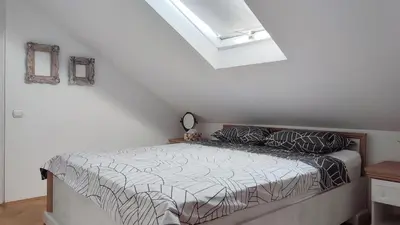 a bedroom with a bed in a white room at Mila LOFT city center-free parking in Vranje