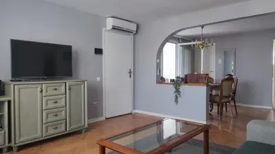 a living room with a tv and a glass table at Mila LOFT city center-free parking in Vranje