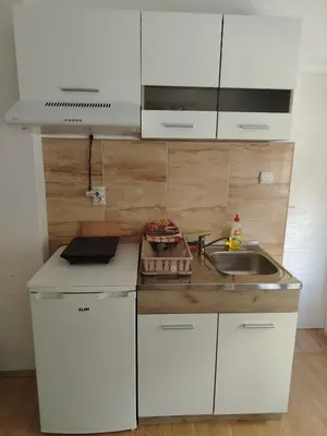 a kitchen with white cabinets and a sink at Apartmani Trifunović 2 in Soko Banja