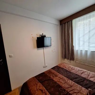 a bedroom with a bed and a tv on the wall at Kraljevski kutak Kraljevi čardaci in Kopaonik