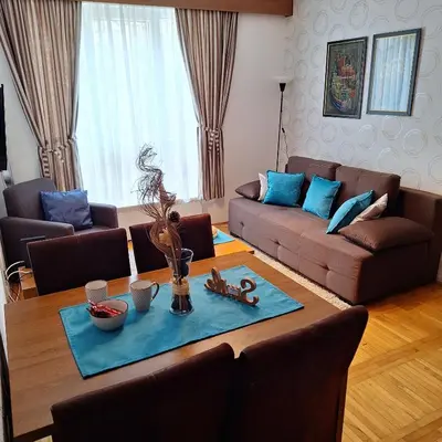 a living room with a table and a couch at Kraljevski kutak Kraljevi čardaci in Kopaonik