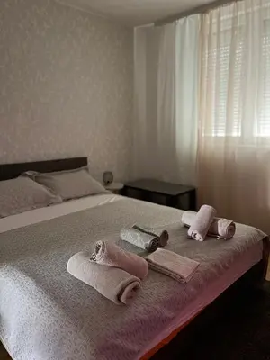 a bedroom with a bed with towels on it at Lana Apartman in Niš