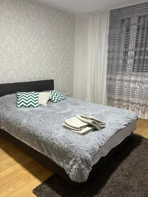 a bedroom with a bed with two towels on it at Lana Apartman in Niš
