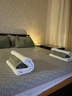 a bed with two towels on top of it at Lana Apartman in Niš