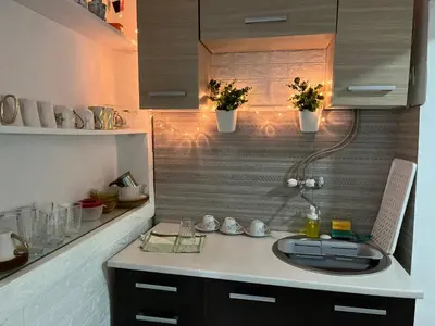 a kitchen with a sink and a counter with lights at Lana Apartman in Niš