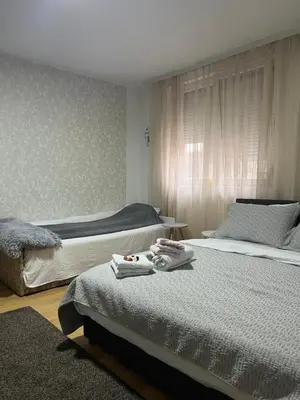a bedroom with two beds with towels on them at Lana Apartman in Niš