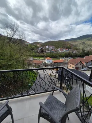 a balcony with two chairs and a view of a town at Apartmani Banjski Biser in Jošanička Banja