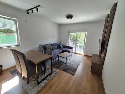 a living room with a table and a couch at Apartmani Banjski Biser in Jošanička Banja