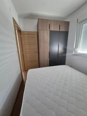 a bedroom with a bed and a wooden door at Apartmani Banjski Biser in Jošanička Banja