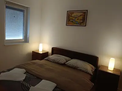 a bedroom with a bed and two lights on two tables at Apartman Petrovic 4 in Soko Banja