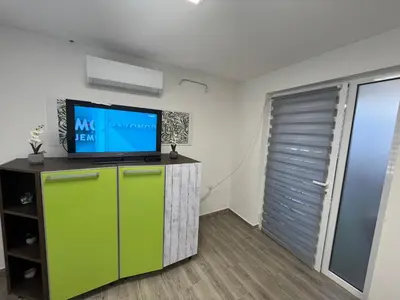 a living room with a tv on top of a refrigerator at Apartman city in Niš