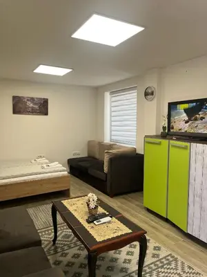a living room with a couch and a green refrigerator at Apartman city in Niš