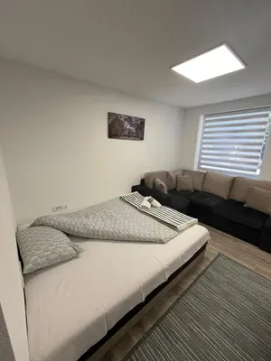 a bedroom with a bed and a couch at Apartman city in Niš