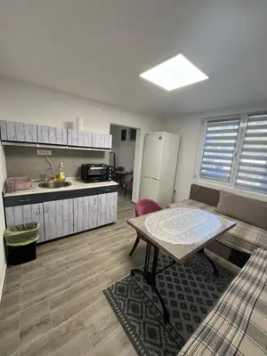 a small kitchen with a table and a refrigerator at Apartman city in Niš