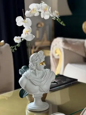 a white statue sitting on a table with a flower at Vila Safra in Vrnjačka Banja