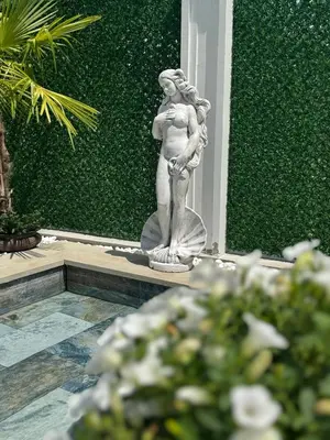 a statue of a woman standing in a garden at Vila Safra in Vrnjačka Banja