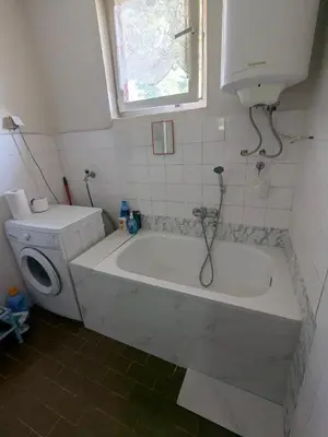 a white bath tub in a bathroom with a toilet at Gordana in Senjski Rudnik