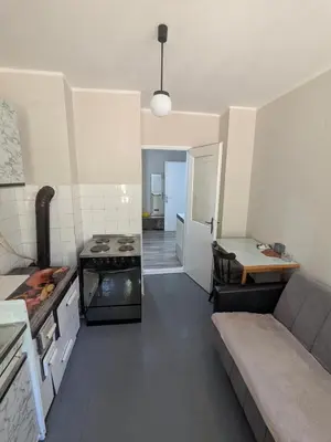 a kitchen with a stove and a couch in a room at Gordana in Senjski Rudnik