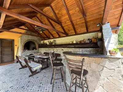 a patio with a table and chairs and a bar at Trnova Ruzica in Trnovac