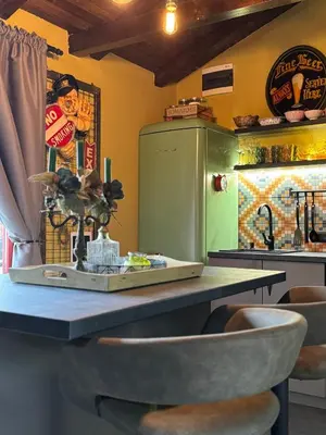 a kitchen with a counter with a table and a refrigerator at Trnova Ruzica in Trnovac