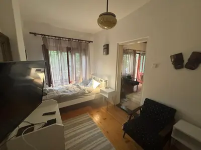 a living room with a television and a bed in a window at Rustik in Soko Banja