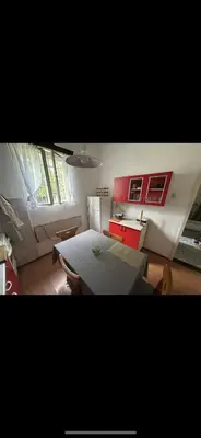 a room with a bed and a kitchen with red cabinets at Rustik in Soko Banja