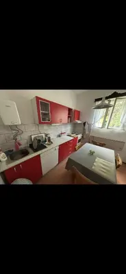 a kitchen with red cabinets and a table in it at Rustik in Soko Banja