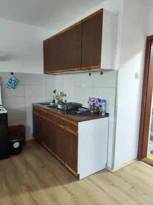a kitchen with wooden cabinets and a white refrigerator at Milijic Lux 2 in Soko Banja