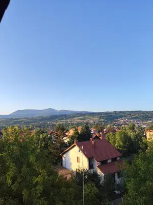 a house on a hill with trees and mountains in the background at Milijic Lux 2 in Soko Banja