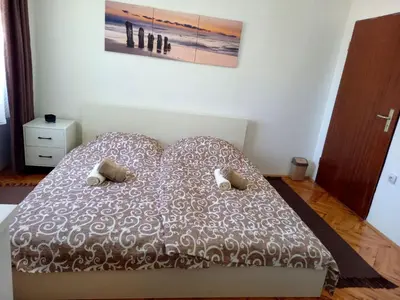 a bedroom with a bed with a brown and white comforter at Apartman KEJ 64m2 in Surdulica