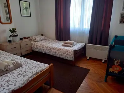 a small bedroom with two beds and a window at Apartman KEJ 64m2 in Surdulica