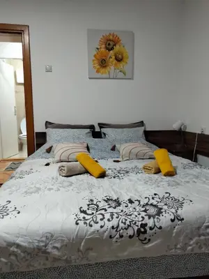 a bedroom with a large bed with yellow pillows at Apartment studio Ignjatovic in Niš