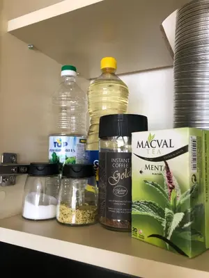 a shelf with bottles of water and other food items at ANNI apartman in Paraćin